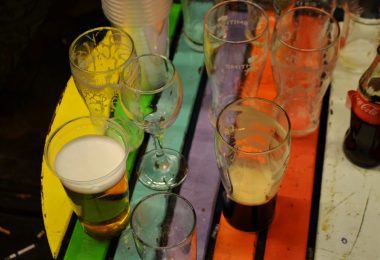 Worn and dirty wooden table painted in the different colours of the rainbow set up outside on the streets of dublin for placing empty beer and cider glasses drinks onto it in sweeneys ba