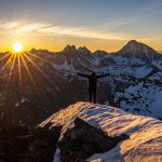 person standing on cliff during golden hour