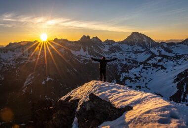 person standing on cliff during golden hour