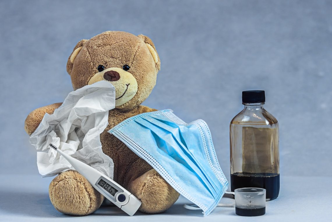 brown bear plush toy on blue textile