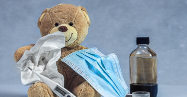 brown bear plush toy on blue textile