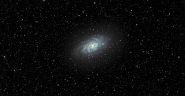 a very bright blue object in the middle of a dark sky