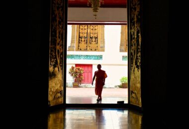 woman in red long sleeve shirt and pants walking on brown wooden floor