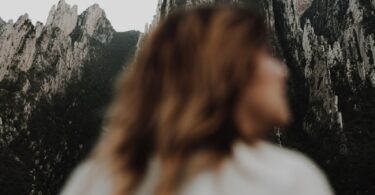A woman standing in front of a mountain range