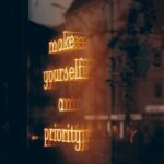 A neon sign that says make yourself on priority