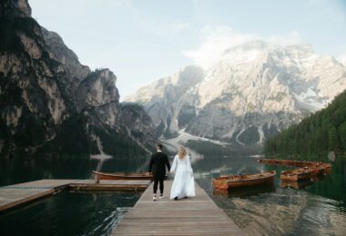 A bride and groom are standing on a dock