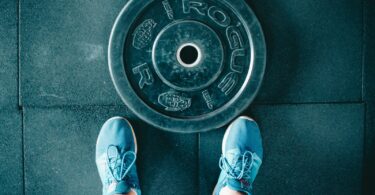 person standing beside black weights