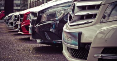 Luxury cars lined up at an outdoor dealership, showcasing sleek designs.