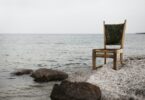 brown wooden parsons chair on gray beach sand