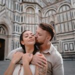 Couple embracing in front of a historic cathedral