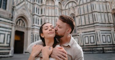 Couple embracing in front of a historic cathedral
